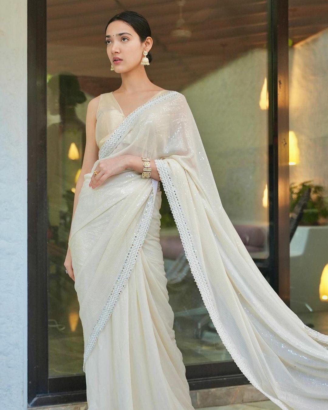 For the wedding season, Medha shines in a stunning white saree, complemented by signature no-makeup elegance, a black bindi, and exquisite Jhumkas