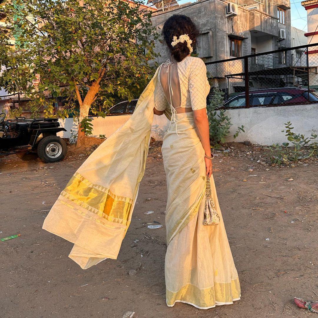 Wearing a gorgeous white saree with a golden border, she paired it with a backless blouse and an elegant potli bag. This look is a perfect 10, radiating sophistication