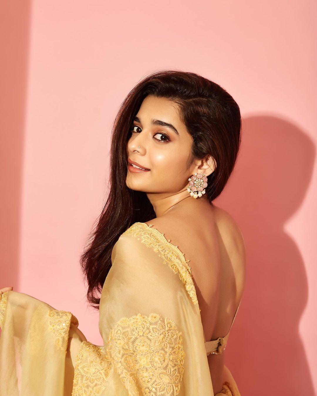 Leaving her hair open, she opted for contrasting pink earrings and a nude makeup look that's simply breathtaking. This ensemble is a perfect balance of elegance and vibrancy