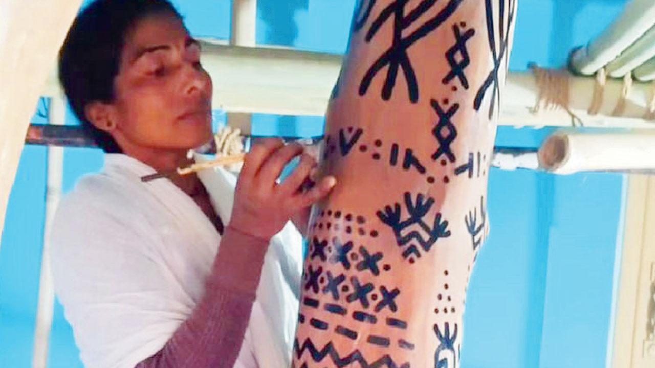Jamini Bai showcases Baiga tribe symbols of social significance on a bark