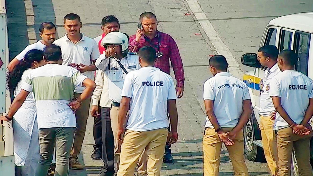 Police and toll plaza personnel attempt to reason with the woman who ventured onto the Bandra Worli Sea Link on Tuesday. Pics/Ashish Raje