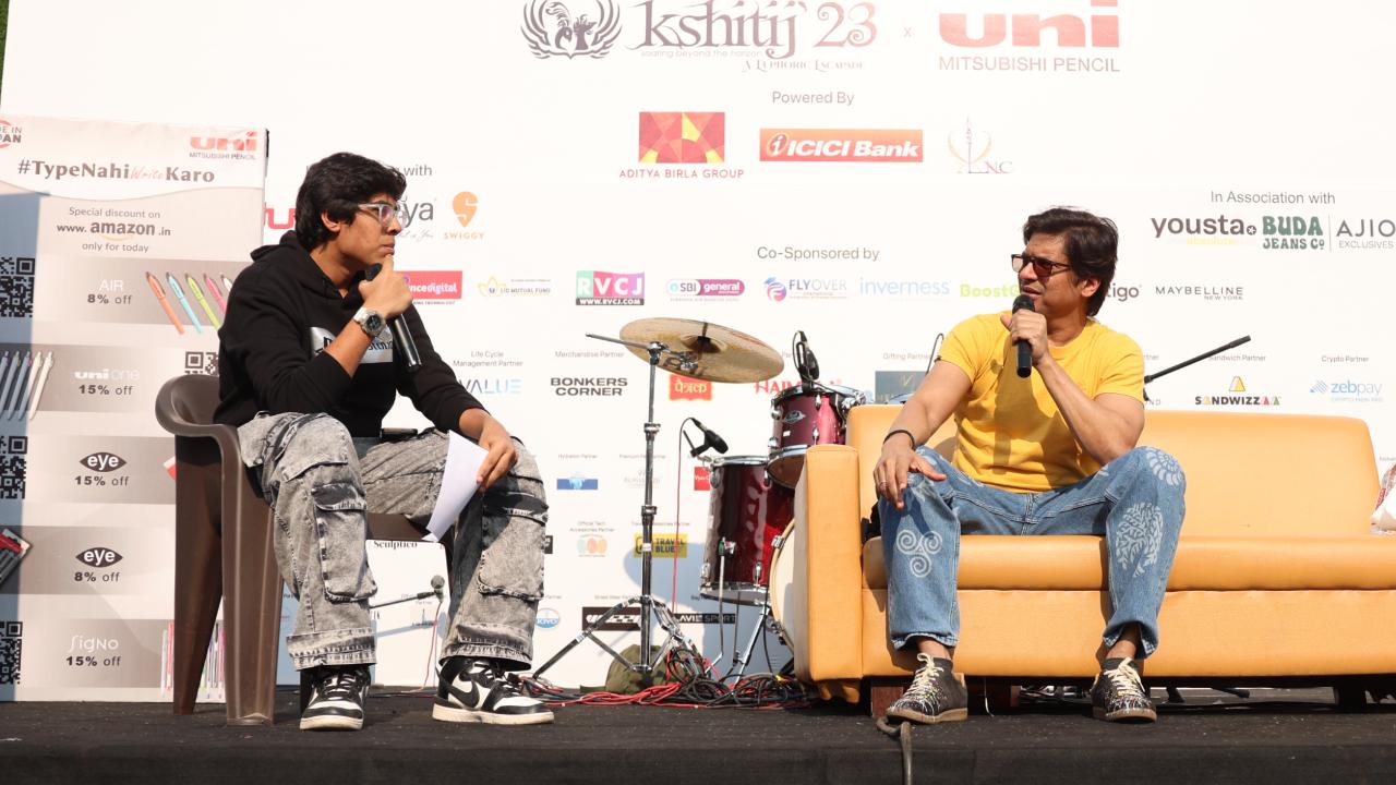 Shaan engrossed in conversation amidst the lively ambiance of JVPD Ground during the Mithibai Kshitij event, radiating enthusiasm and intellect as he shares insights, creating a captivating moment of connection and exchange in the heart of the vibrant gathering