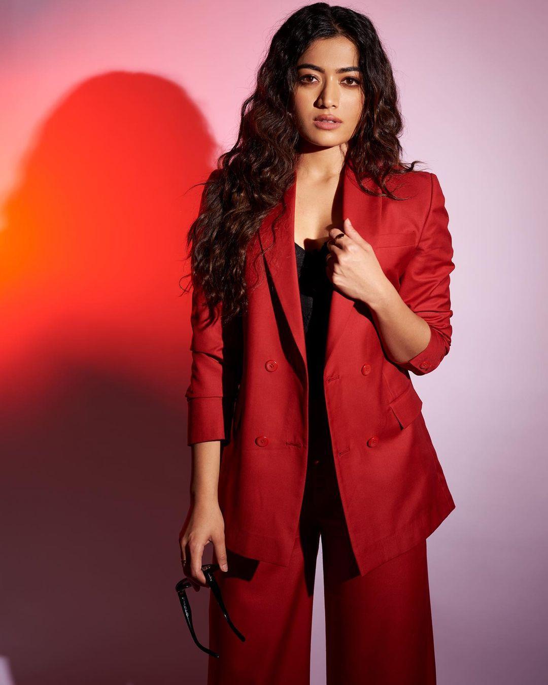 The red suit, paired with curled hair and soft shimmery eyeshadow, captures attention and admiration