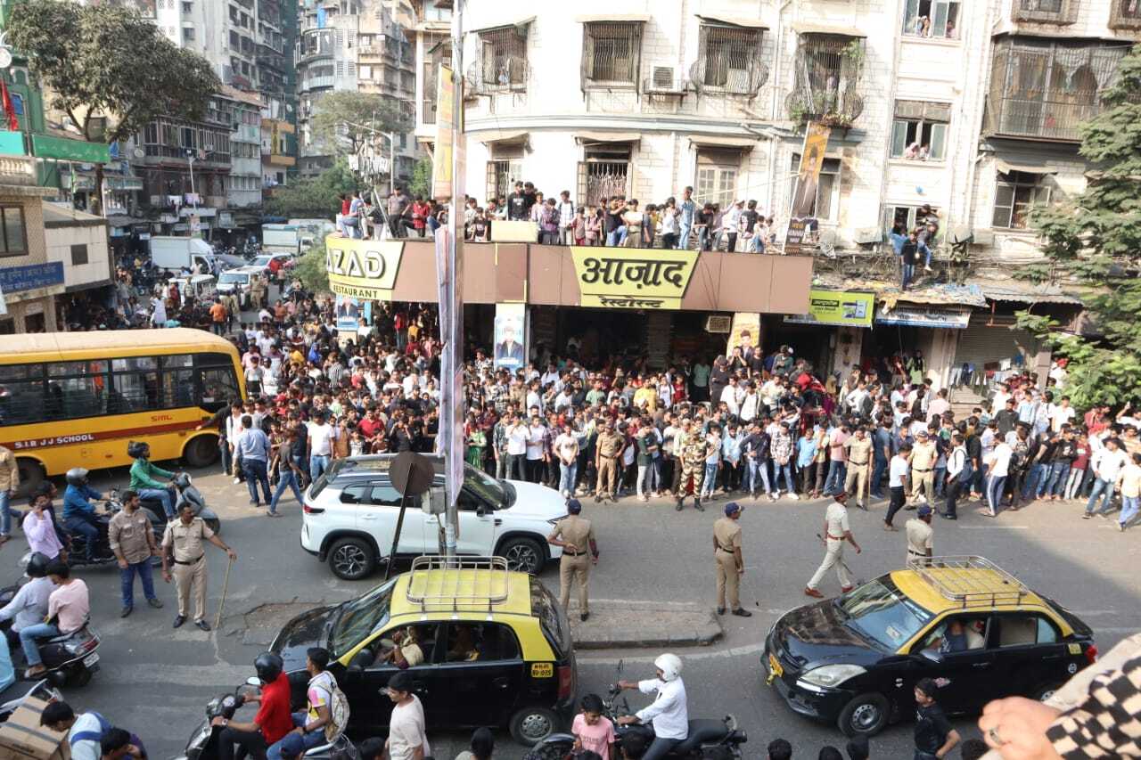 Fans gathered on the footpath, rooftop of shops while some looked through the window of their house