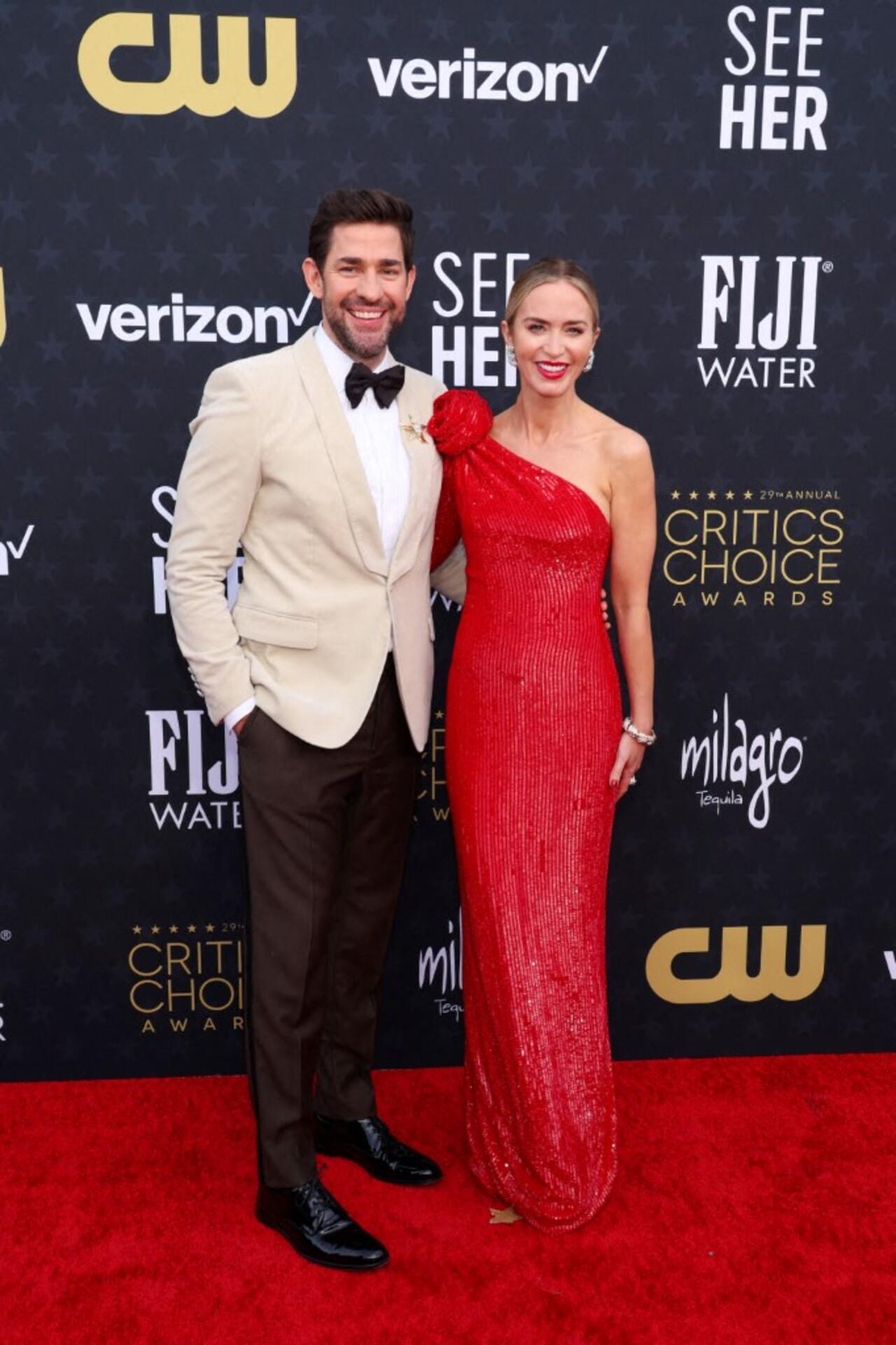 John Krasinski and Emily Blunt make for an adorable pair as they pose together on the red carpet. Emily opted for a striking red evening gown while John opted for a dapper off-white suit for the night