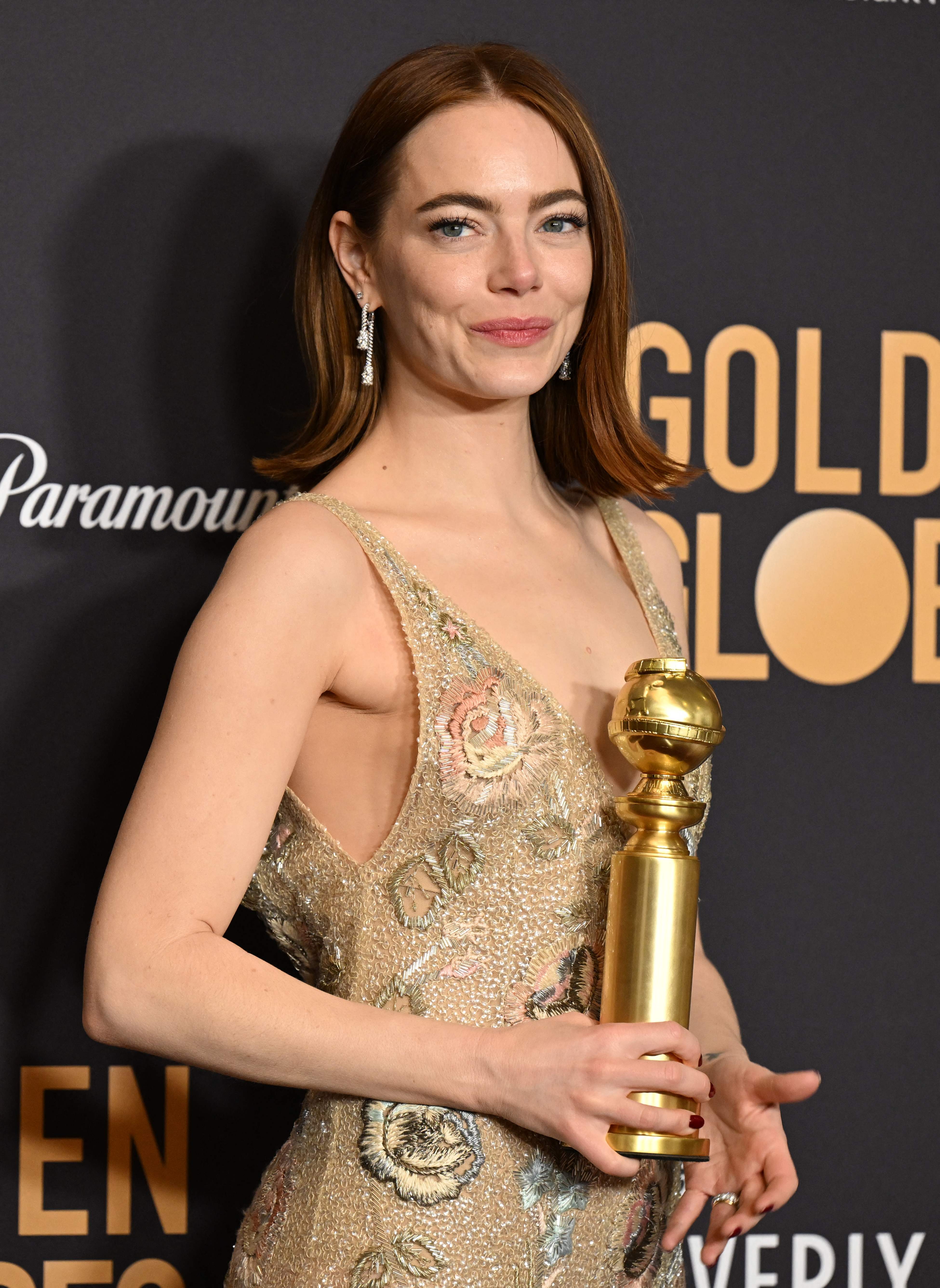 Actress Emma Stone poses with the award for Best Performance by a Female Actor in a Motion Picture - Musical or Comedy for 