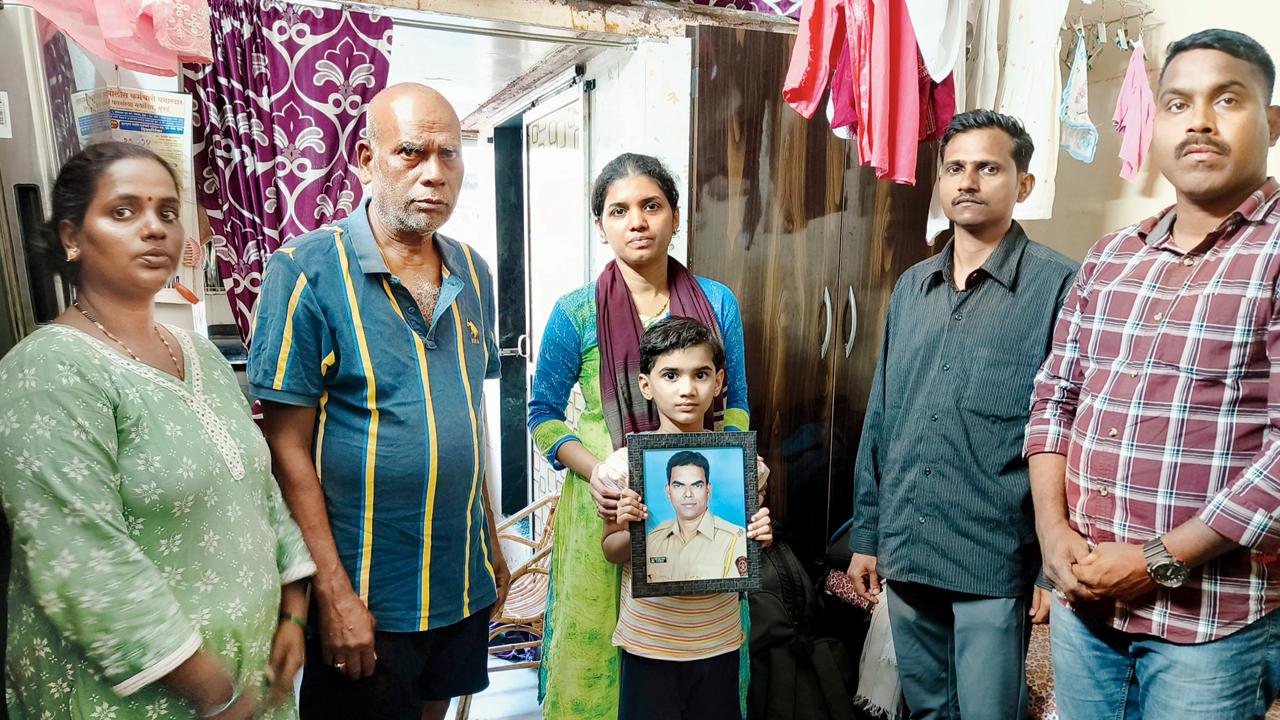 Constable Sameer Jadhav’s wife Aparna and daughter Swara, surrounded by relatives, hold a portrait of the deceased police officer at the family’s Worli residence on Sunday. Pic/Shirish Vaktania
