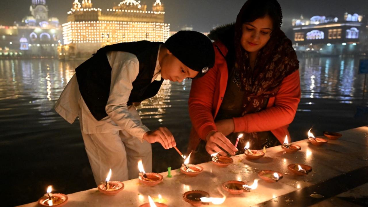 Devotees light earthen lamps on the occasion of the birth anniversary celebrations of the tenth Guru of the Sikhs, Guru Gobind Singh at the Golden Temple in Amritsar 