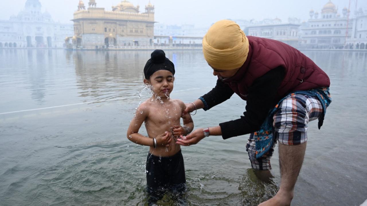 A young Sikh devotee takes a bath in the holy Sarovar (pool) on the occasion of the birth anniversary celebrations of the tenth Guru of the Sikhs Guru Gobind Singh at the Golden Temple in Amritsar