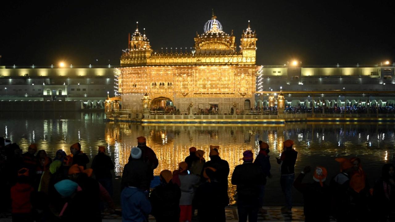 Devotees visit the illuminated Golden Temple complex on the eve of the birth anniversary celebrations of the tenth Guru of the Sikhs, Guru Gobind Singh in Amritsar