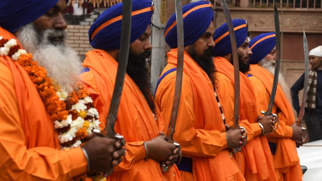 Sikh holy men known as 'Panj Pyare' hold swords during a procession as part of the birth anniversary celebrations