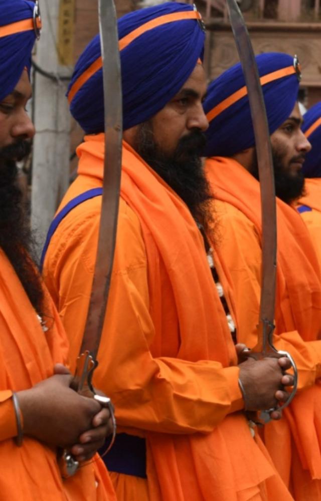 Sikh holy men known as `Panj Pyare` hold swords during a procession as part of the birth anniversary celebrations