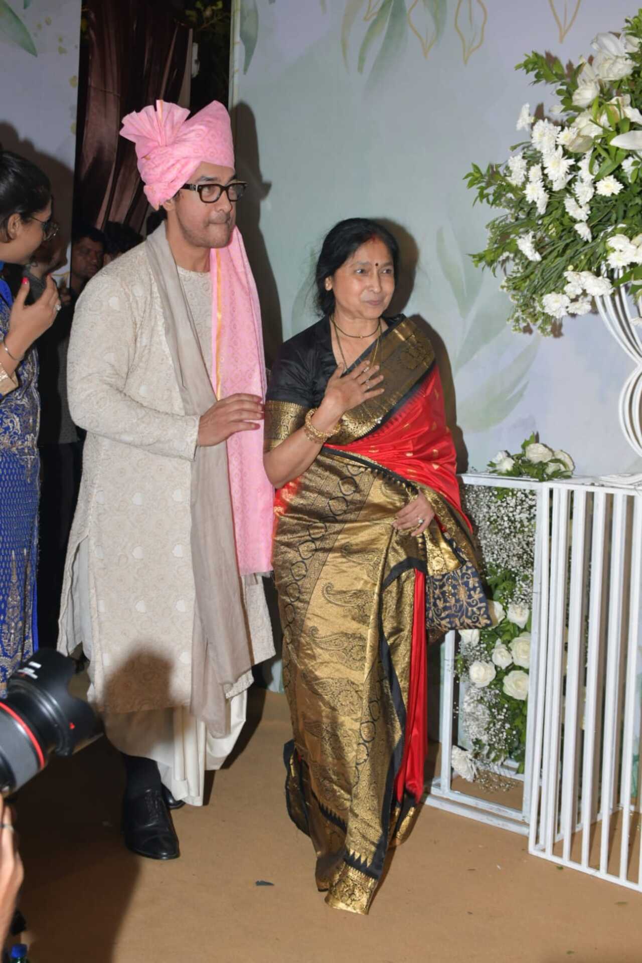 Aamir Khan steps out with Ira's mother-in-law as they head out to greet paps stationed outside the venue. Nupur's mother was dressed in a red saree for the wedding and was seen dancing enthusiastically as his son headed the baraat