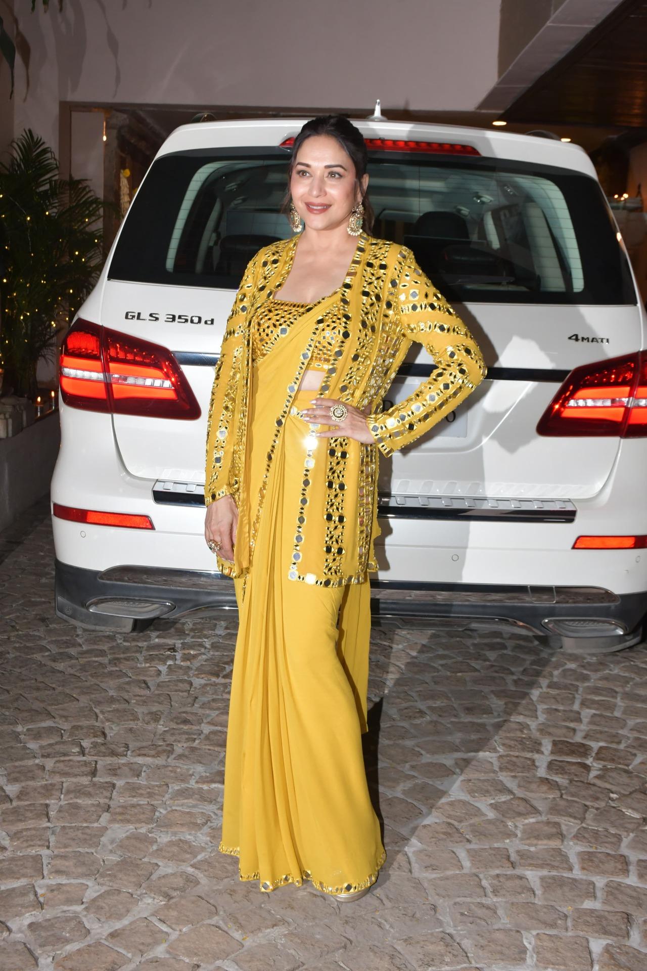 Actress Madhuri Dixit sparkled in a yellow saree with a matching coat with mirror work on it