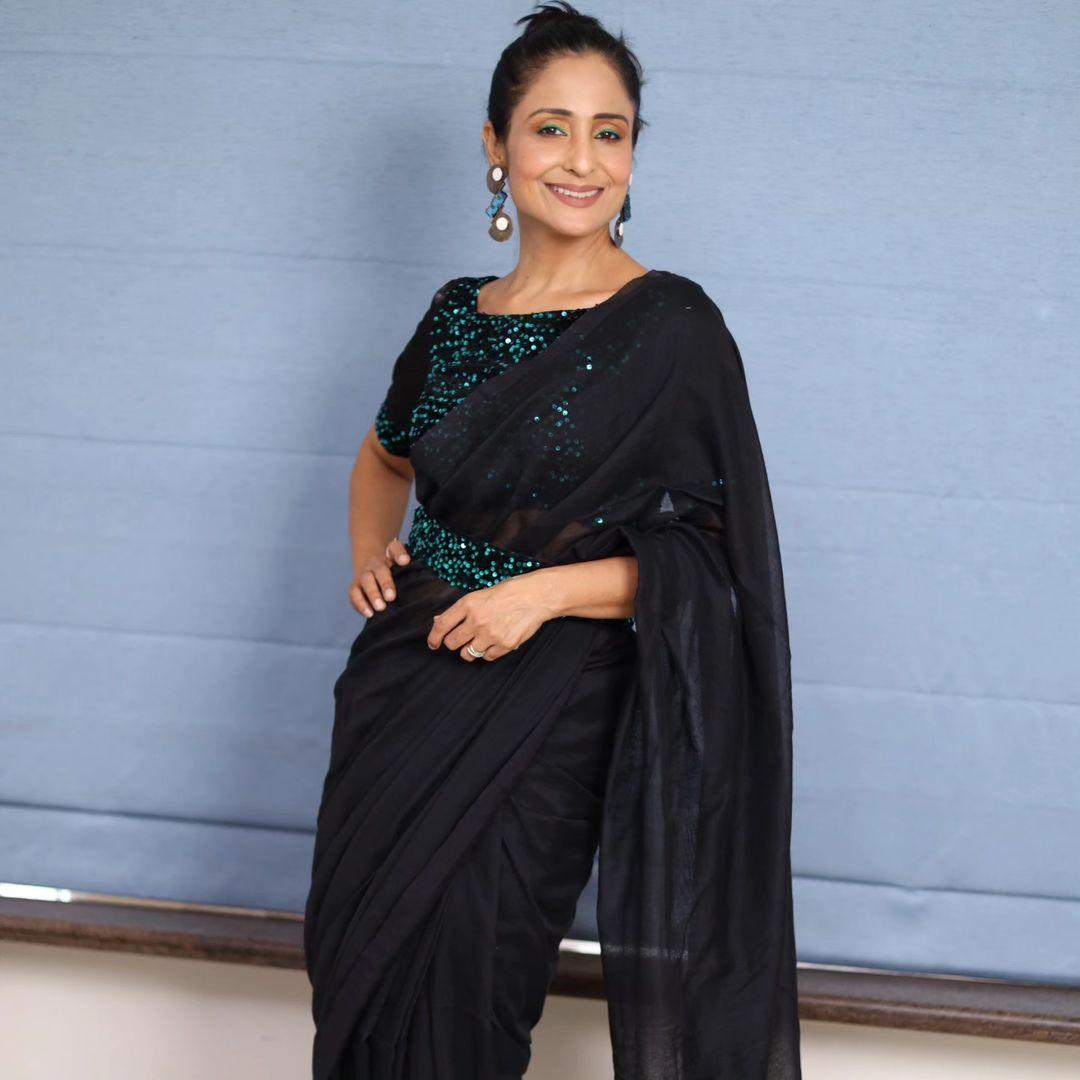 Lataa Saberwal exudes oomph in this shiny sequin saree. The stylish waist belt adds a Western twist to her look, while big earrings strike a balance
