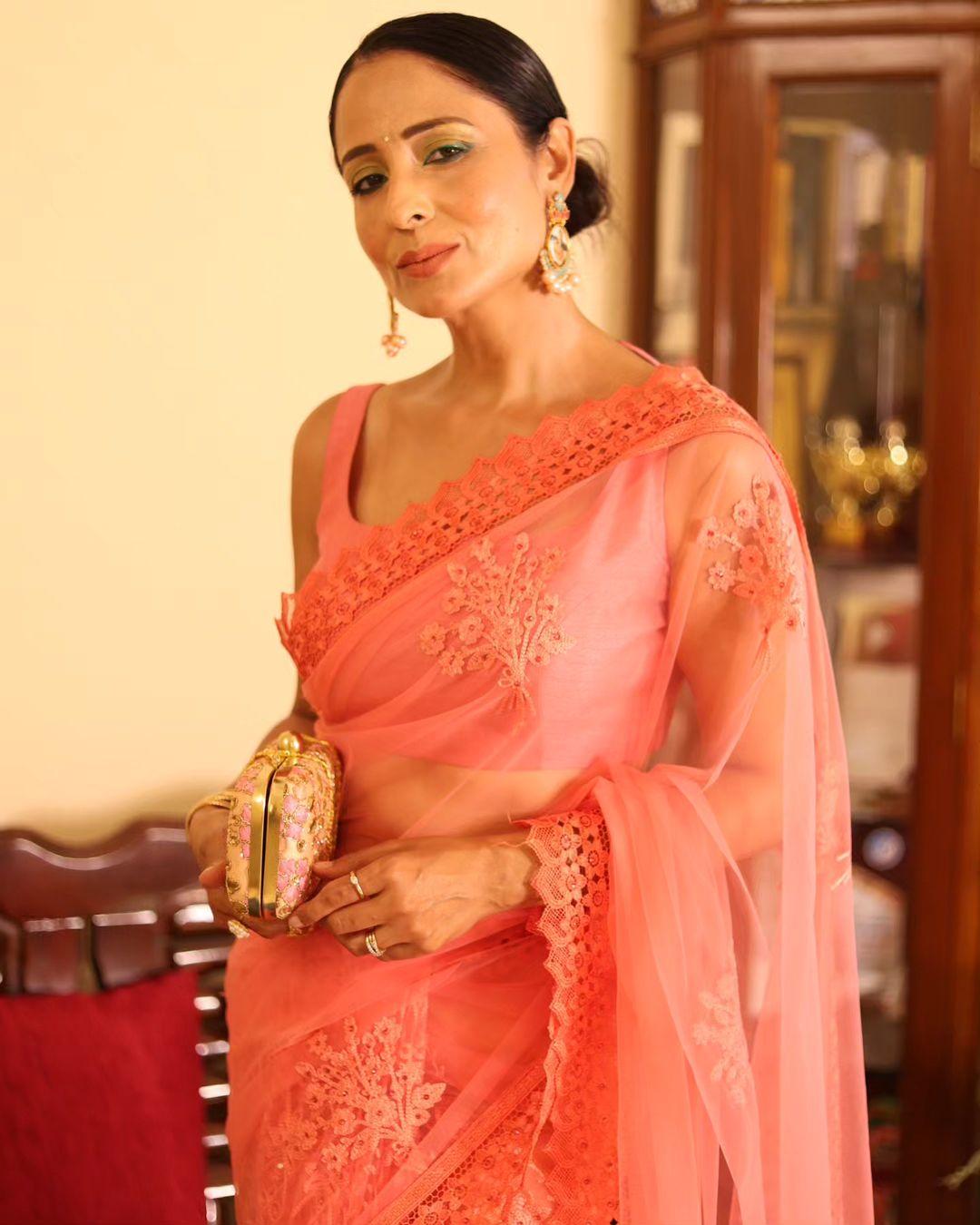 In this beautiful pink see-through saree, Lataa looks like a Barbie. The actress complements the outfit with contrasting green eyeshadow, while her nude makeup enhances her beauty