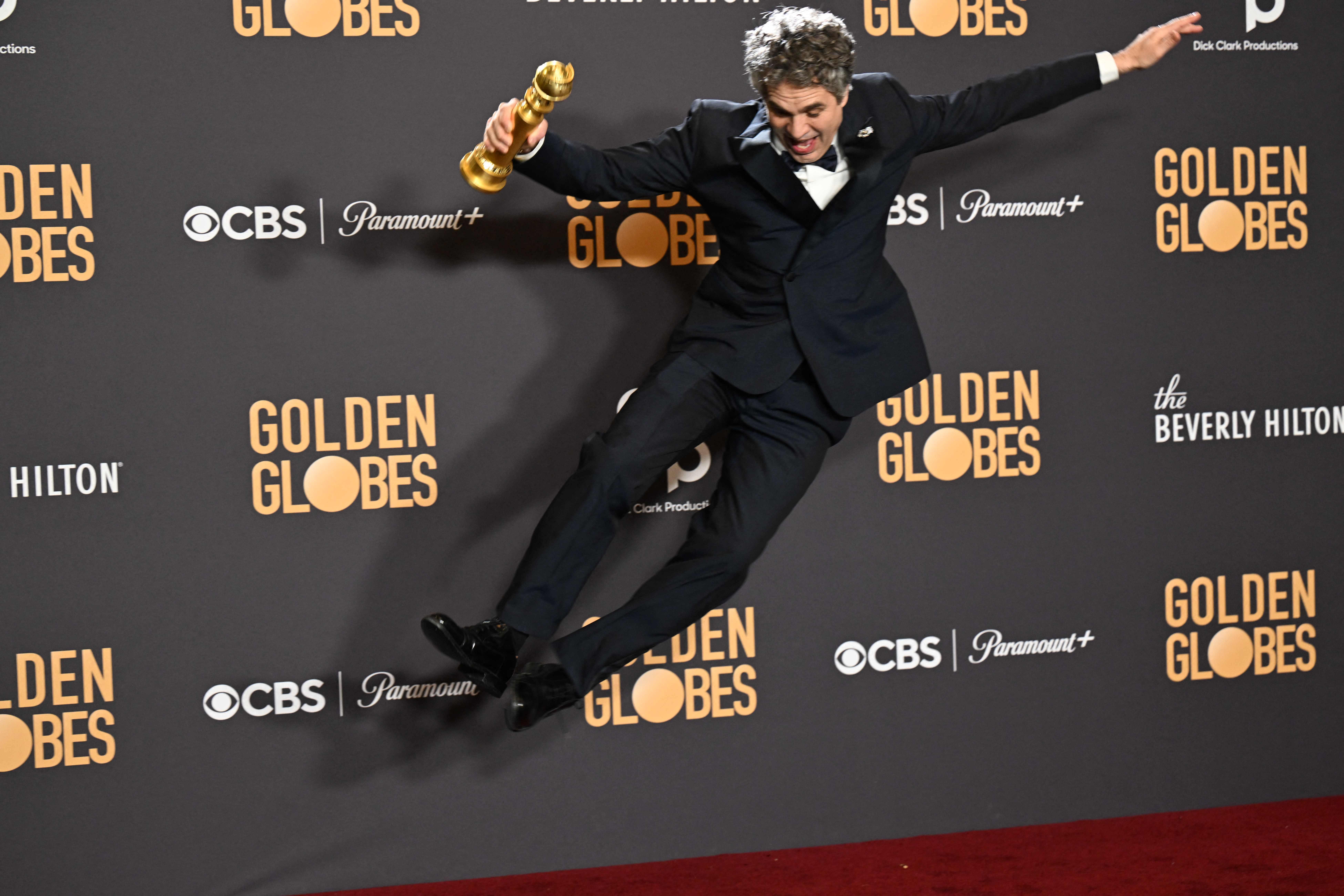 Mark Ruffalo jumps up in joy holding the award for Best Motion Picture - Musical or Comedy - 