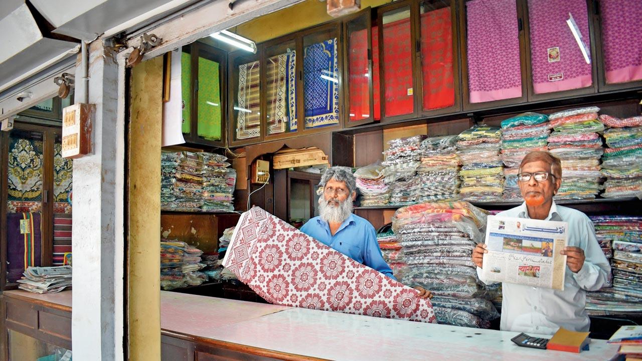 Javed Ahmed Ansari and Ubaidullah Ansari (holding up a copy of Inquilab) at The Bombay City Weavers Co-operative Society store at Inquilab Manzil 