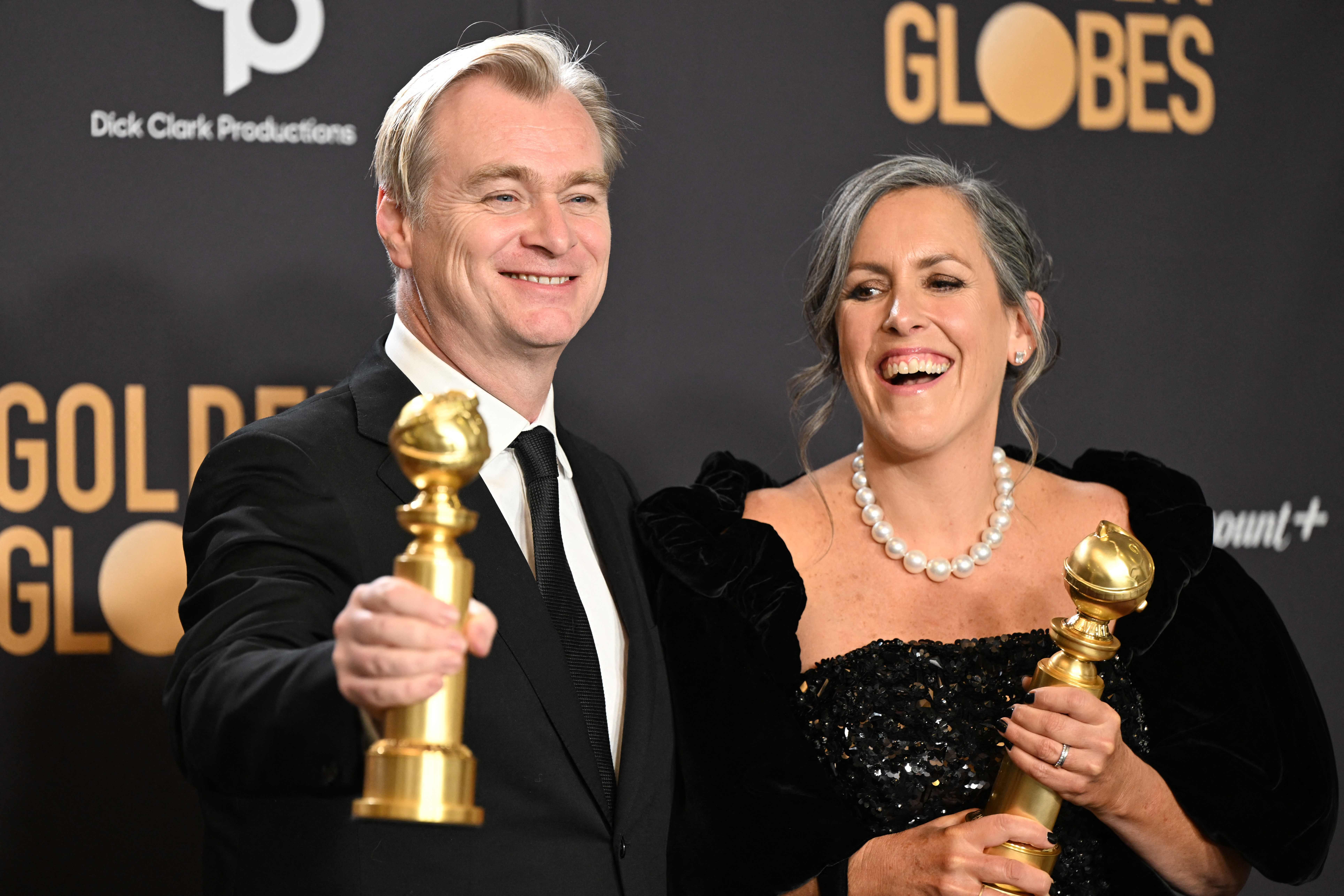 British director Christopher Nolan (L) and spouse British film producer Emma Thomas pose in the press room with the awards for Best Director - Motion Picture and Best Motion Picture - Drama for 