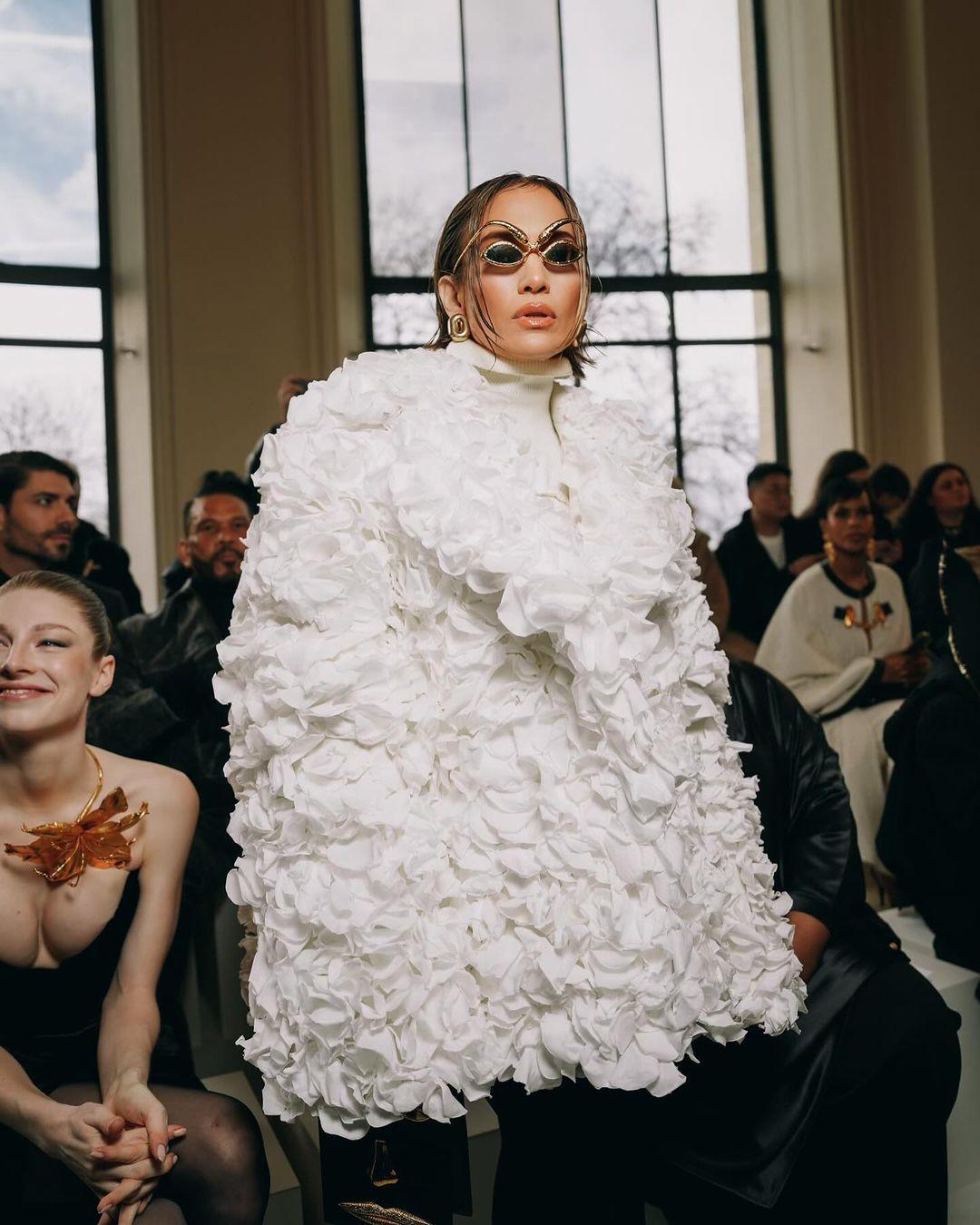 Jennifer Lopez made a stunning appearance at the Schiaparelli Haute Couture show, donning a white coat that was a true work of art. The coat was crafted from an astounding 7,000 real rose petals, with a large silver sequinned sun beautifully embroidered on the back. 