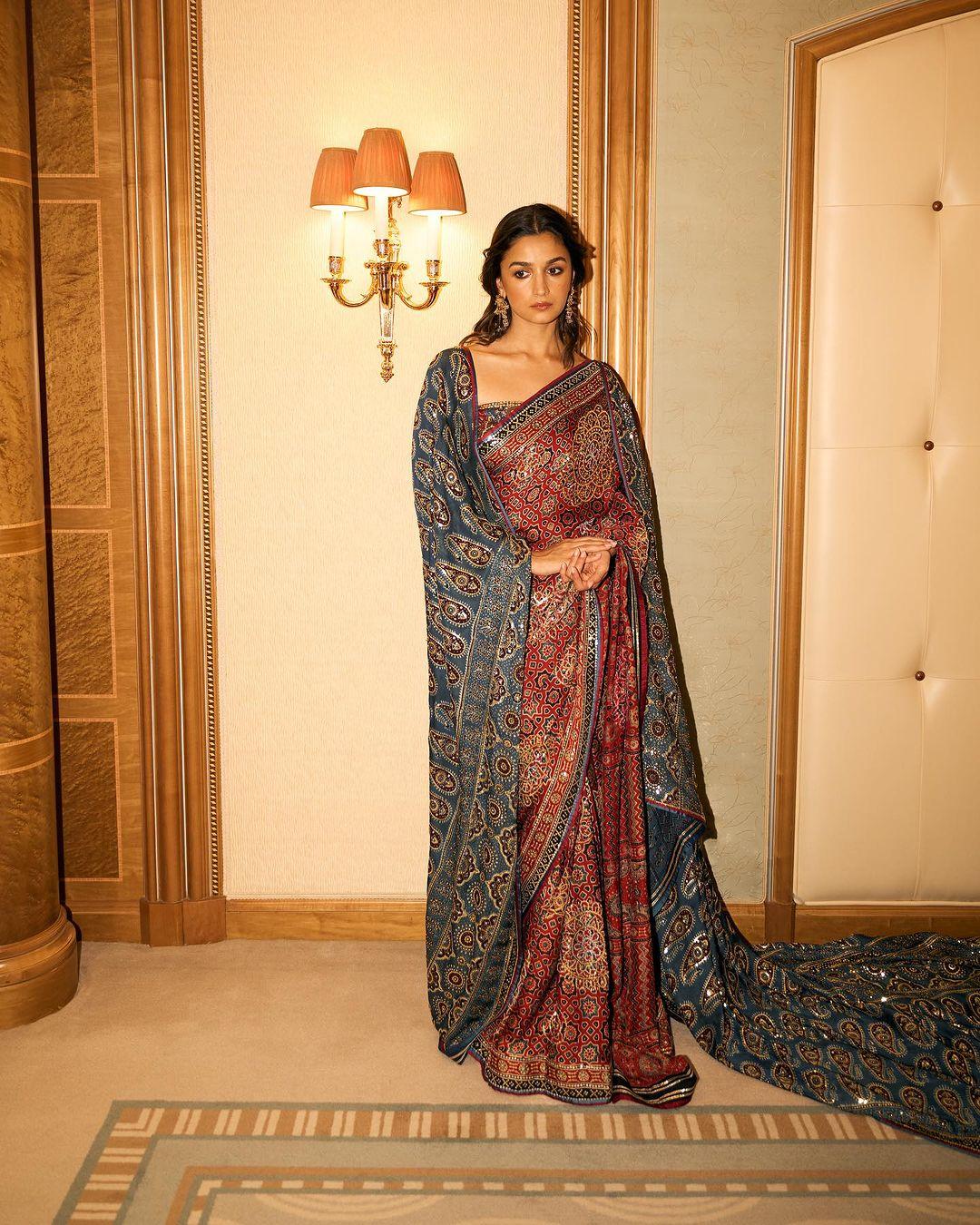 Alia Bhatt's choice of attire is perfect for Republic Day inspiration. She wore a custom-made saree with Ajrakh block-print in blue and red, featuring beautiful gold embroidery to a recent event. The saree was complemented by a blue Ajrakh drape draped over her shoulder. Alia paired the ensemble with a tube-style blouse and kept her hair and makeup bronzed.