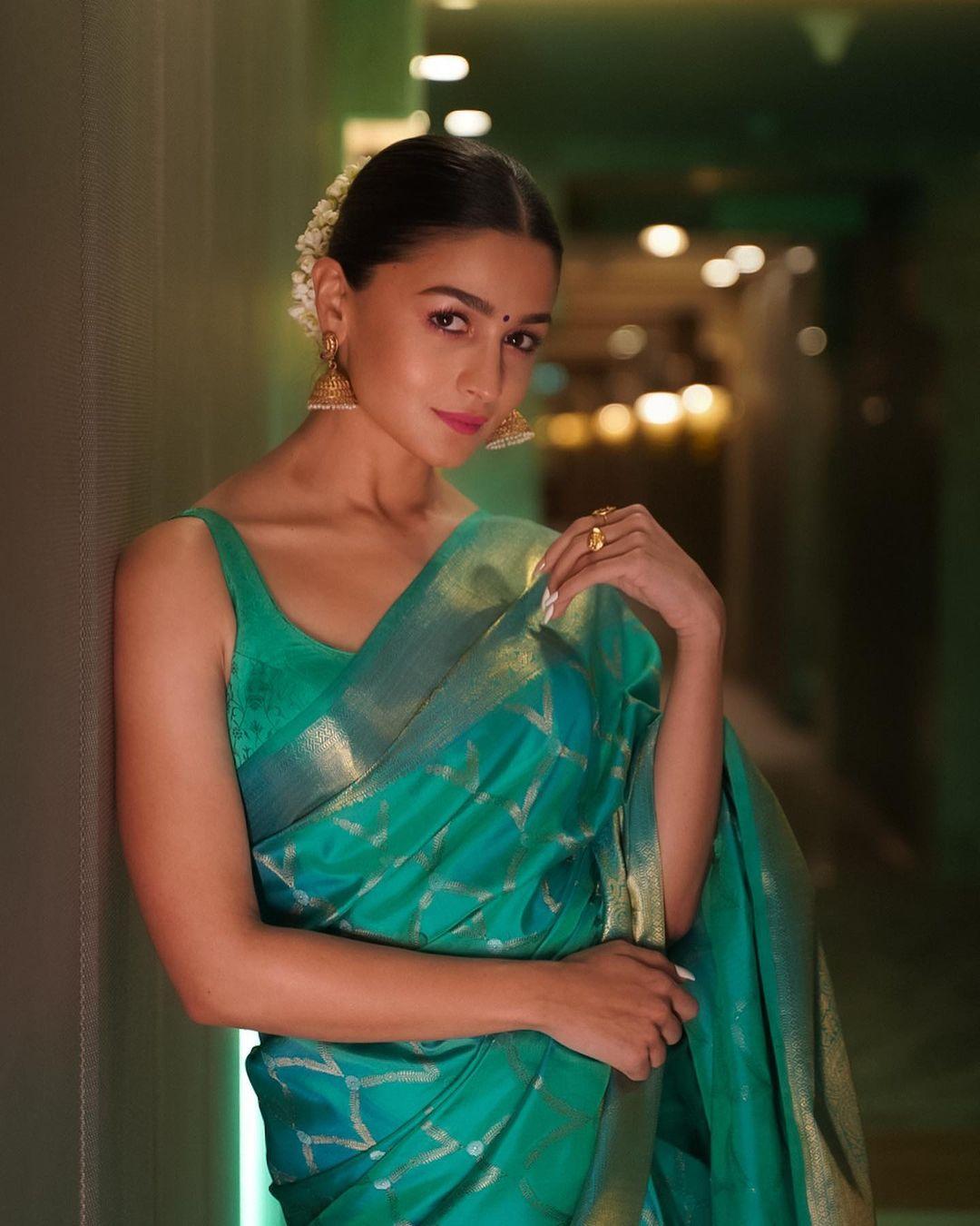 The saree was elegantly paired with a sleeveless blouse in a matching green shade. She styled her hair in a sleek bun