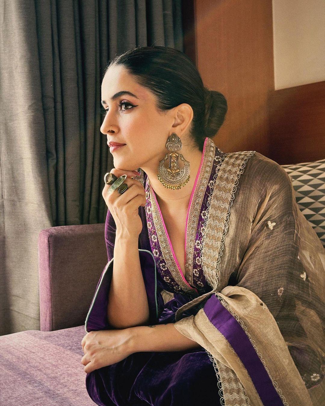 Sanya opted for a luxurious velvet outfit that's perfect for Lohri celebrations. Her long kurta with a V-neck design and golden lace detailing, along with the flared sleeves, added a touch of drama to her look. 