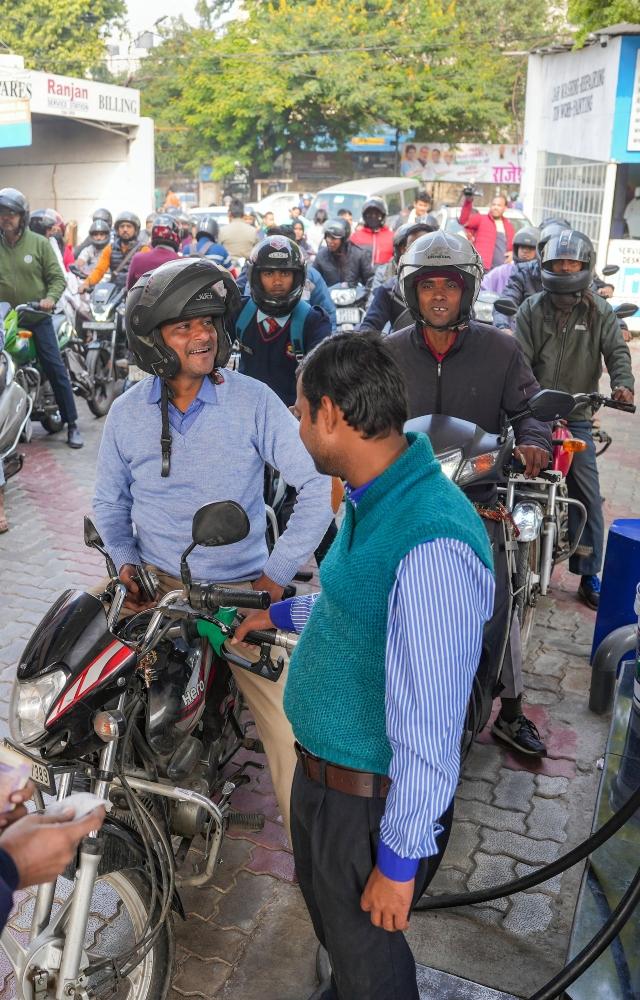 People throng a petrol pump amid the ongoing truck drivers` protest against a provision in the new penal law on hit-and-run accident cases involving motorists