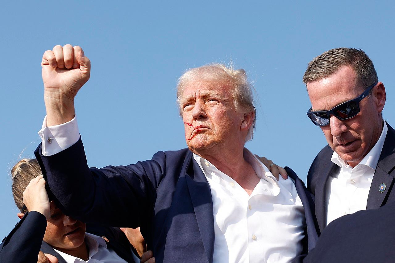 Secret Service agents swarmed Trump and ducked behind the podium. Blood could be seen on his right ear of Trump as agents surrounded him and led him off the stage to a waiting vehicle to whisk him away
