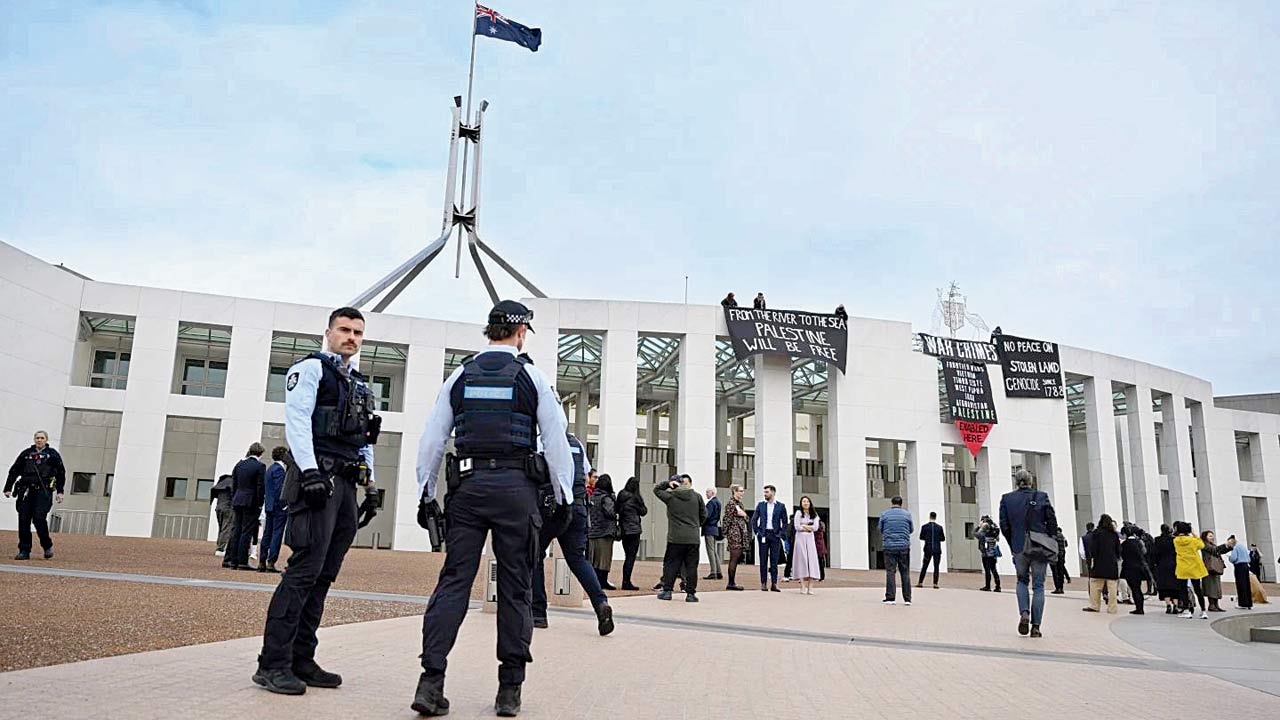 The protesters hung banners above the main entrance to Parliament House in Canberra. Pic/AP