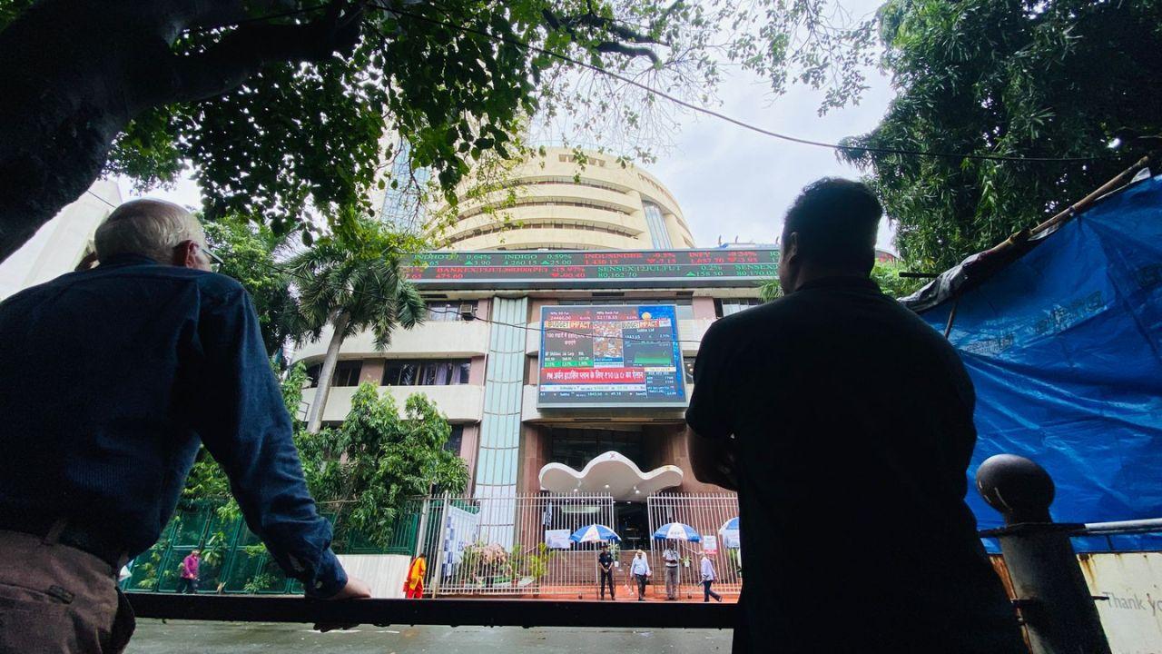 People gathered around and watched the Union Budget 2024 on a big screen outside the Bombay Stock Exchange building at Mumbai's Dalal Street. Pics/ Shadab Khan