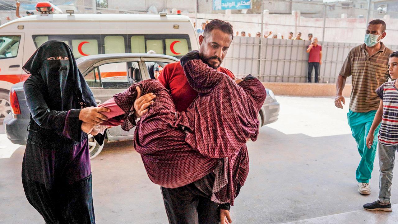 A man carries a woman injured in Israeli attacks in Khan Yunis. Pic/AFP
