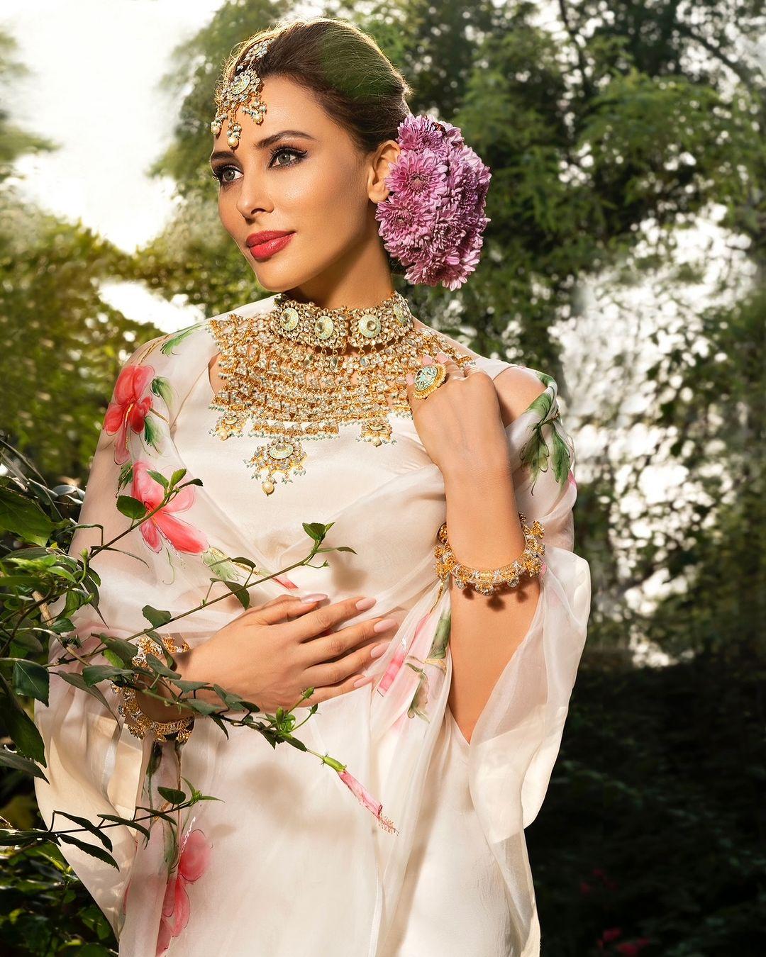 Iulia looked stunning in a white chiffon saree adorned with delicate floral patterns. She paired the saree with a heavy, elaborate necklace and accessorized with beautiful details, including a flower in her hair.