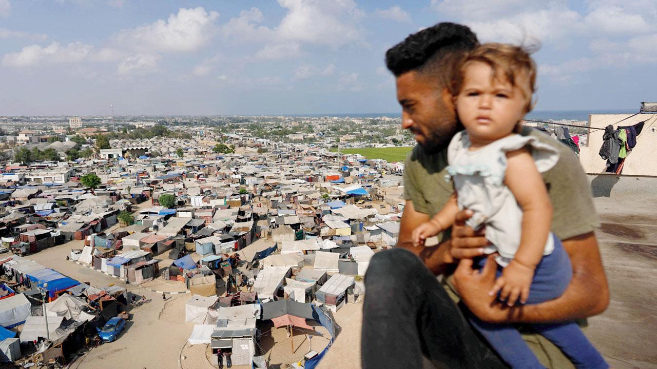 A man and a child backdropped by tents in Khan Yunis on Wednesday. PIC/AFP