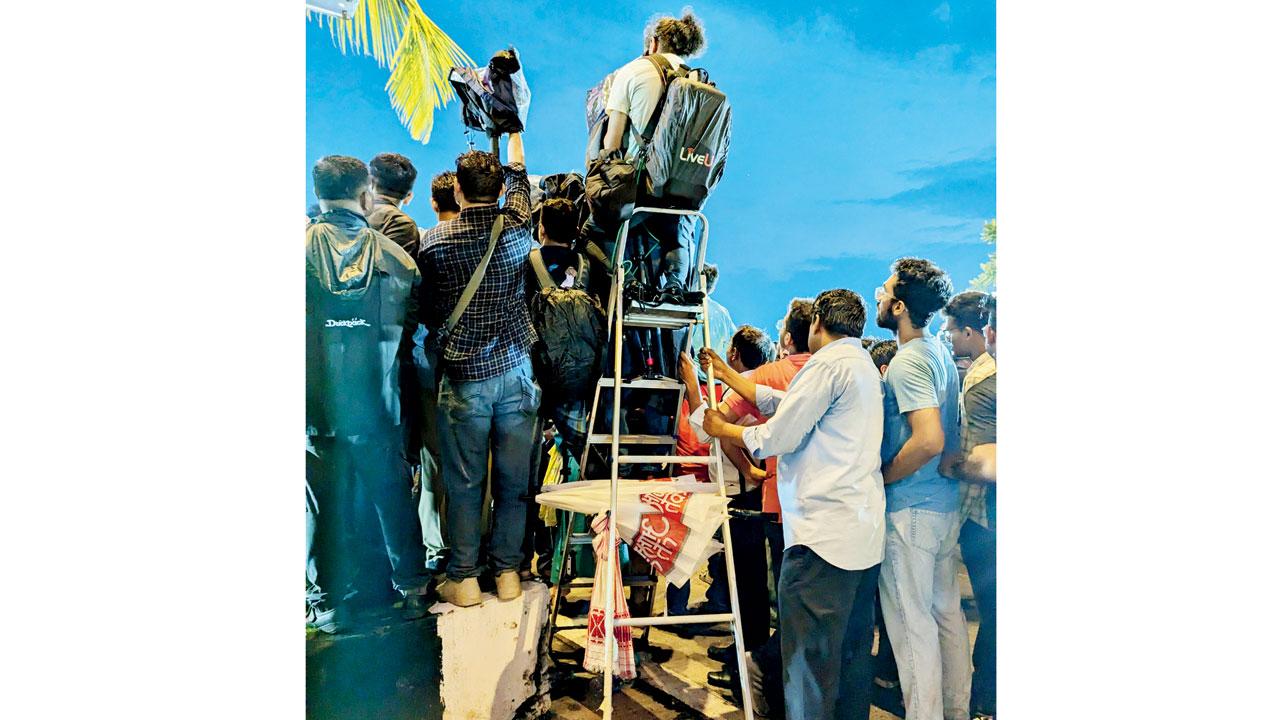 A man atop a ladder tries to get a good shot of the champions 