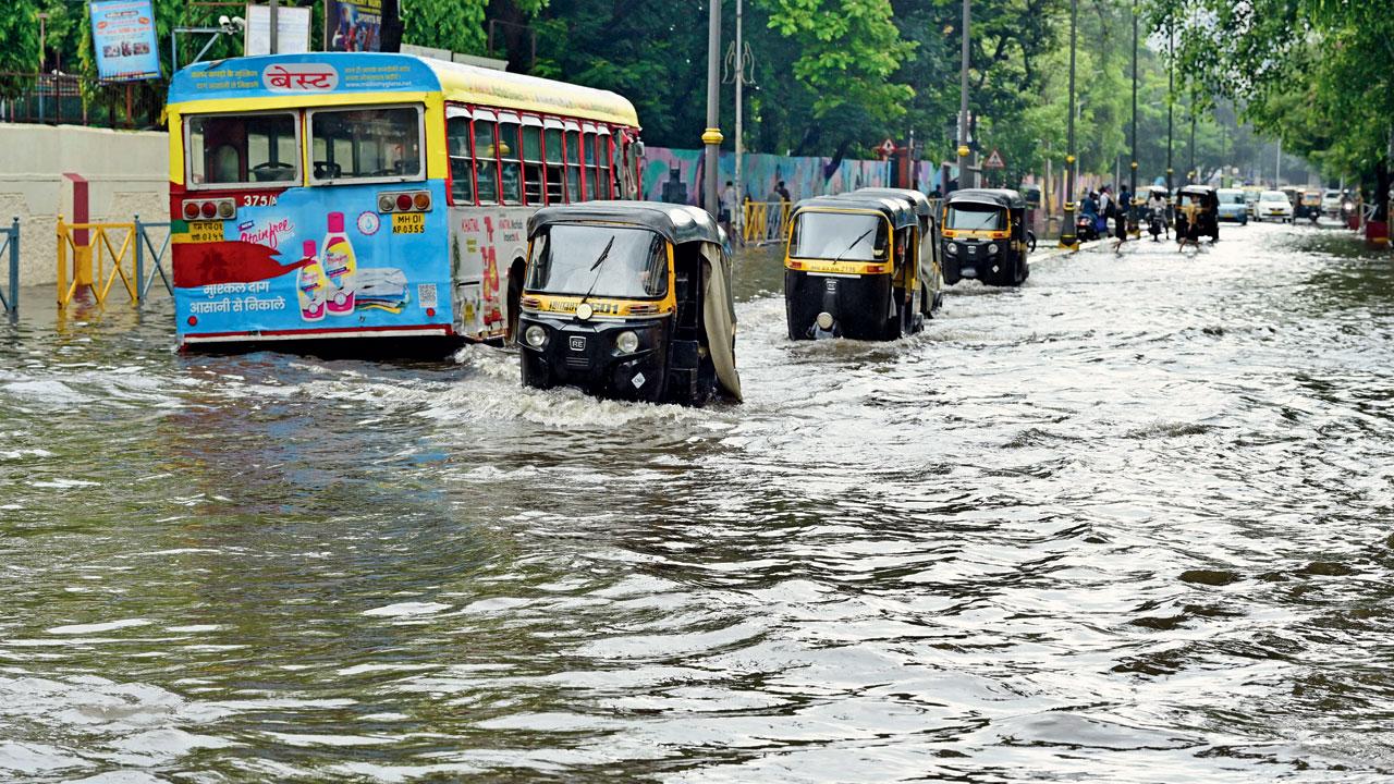 Vehicles struggle through water at Nehru Nagar, Kurla. Pic/Shadab Khan