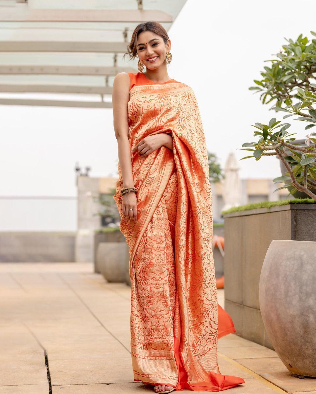 In this stunning saree look, Sana draped herself in a heavily printed orange six yards paired with a matching blouse