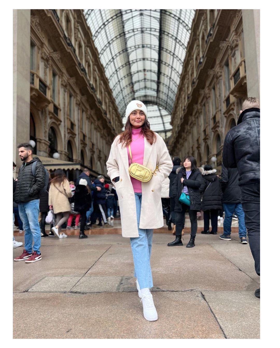 In this picture, Makbul posed beautifully on the streets of Italy, wearing a pink top paired with blue jeans and a white overcoat.
