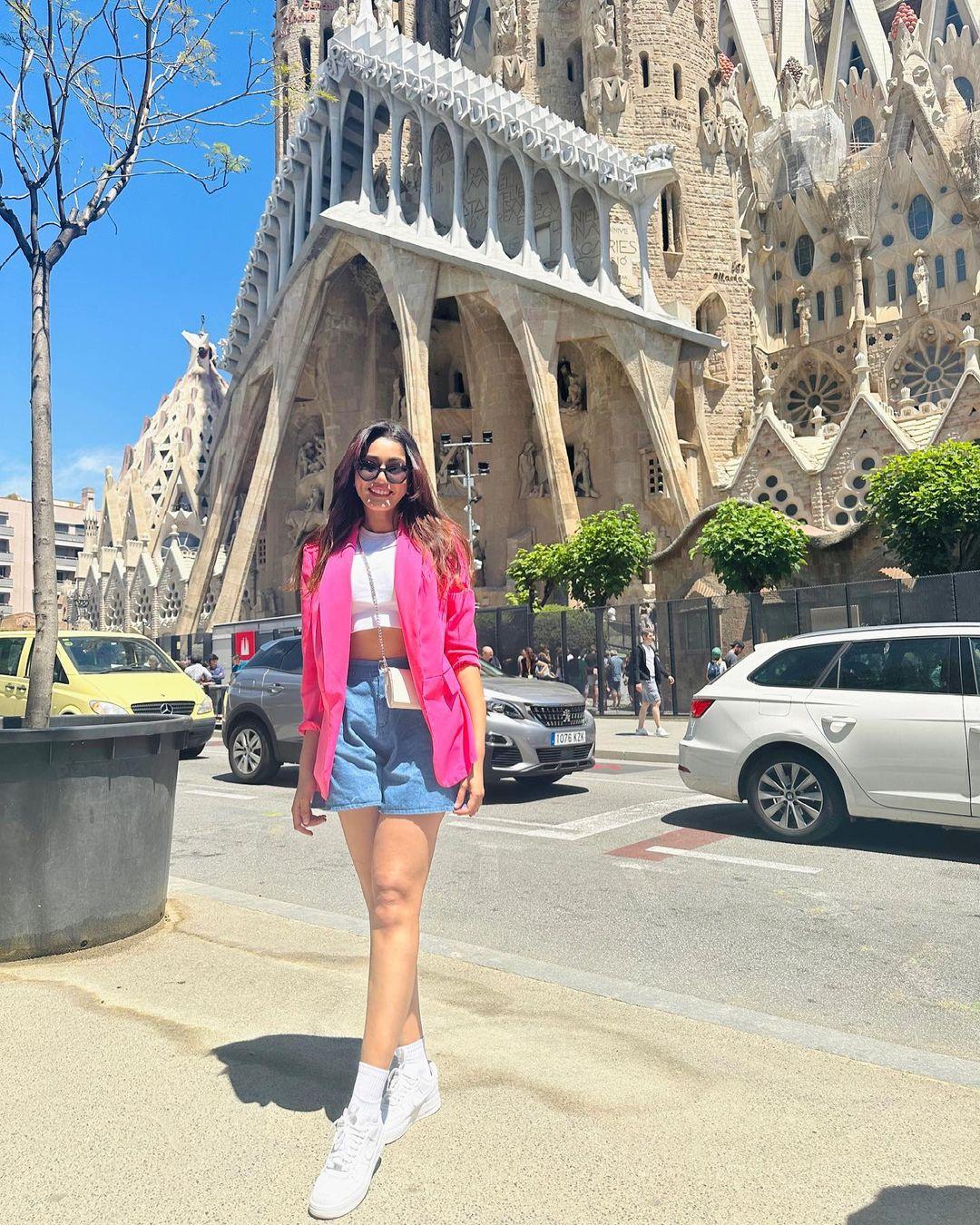 In this picture, the actress is seen wearing blue shorts paired with a white crop top and styled with a pink blazer