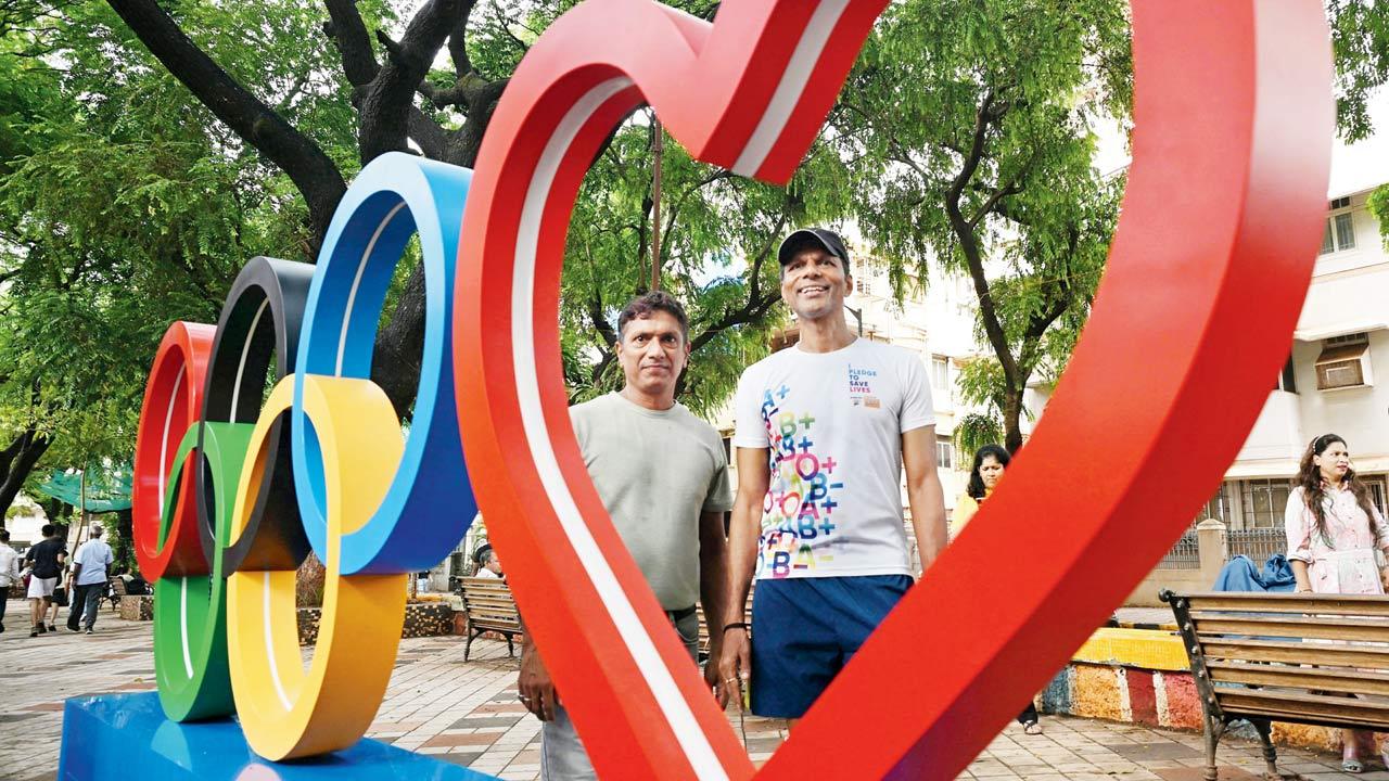 Runners Nitin Gajam and Naveen Hegde with the signage. The structure will move to Carter Rd, Bandra West on July 7 and Marine Drive, later this month. Pics/Ashish Raje