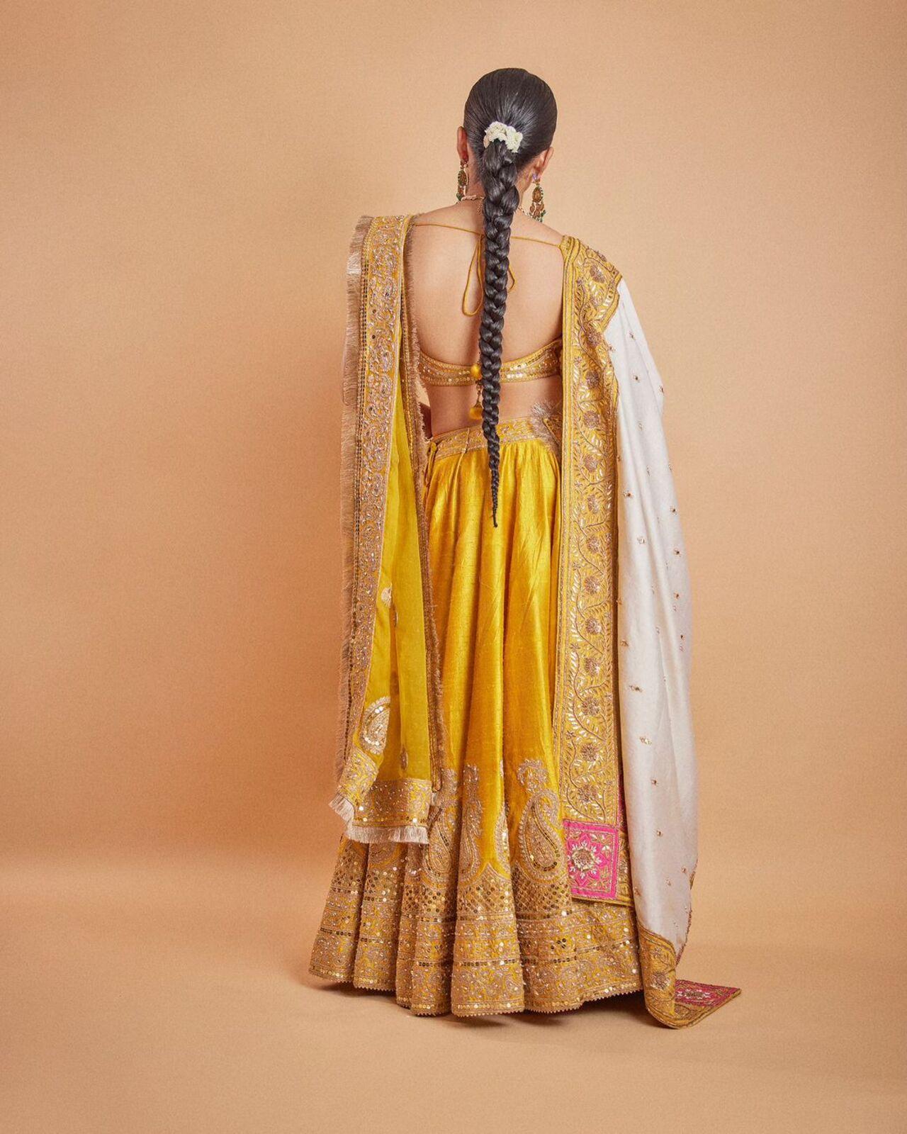Rashmika opted for a stunning yellow lehenga with heavy embroidery at the bottom. She paired the beautiful lehenga with a heavy and long contrasting dupatta