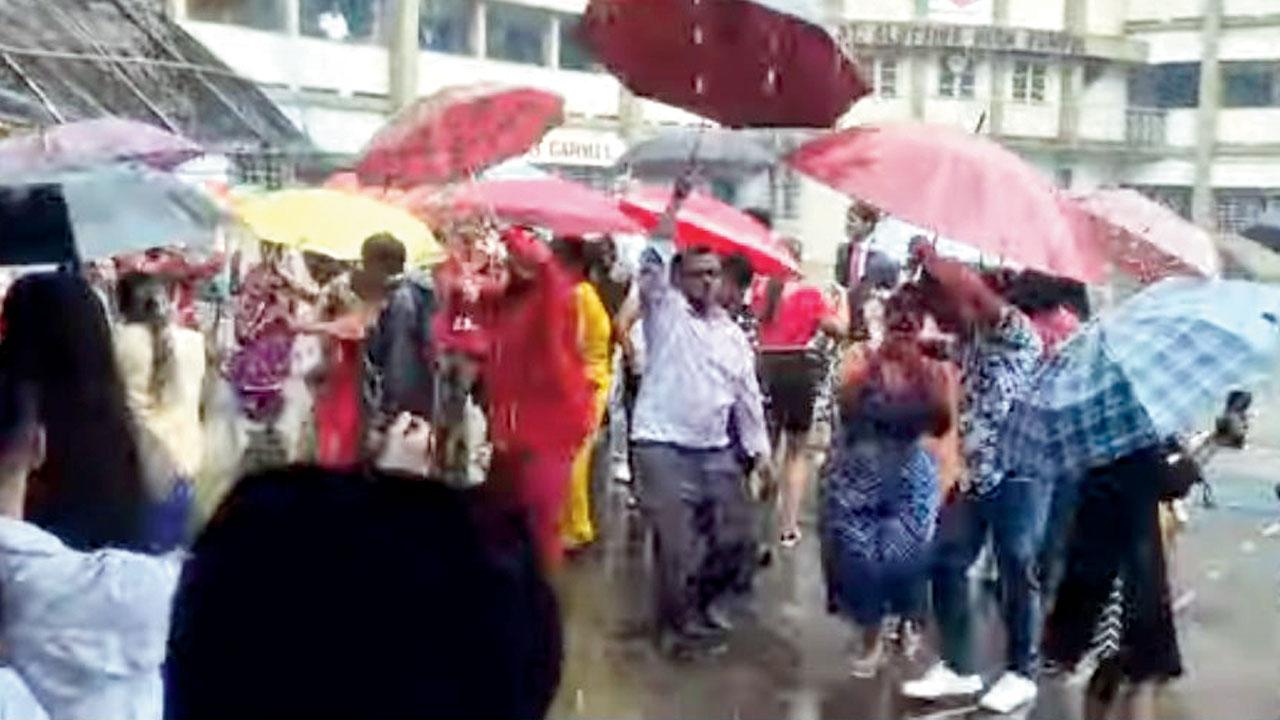 Parshioners dance with their umbrellas open in Bandra West