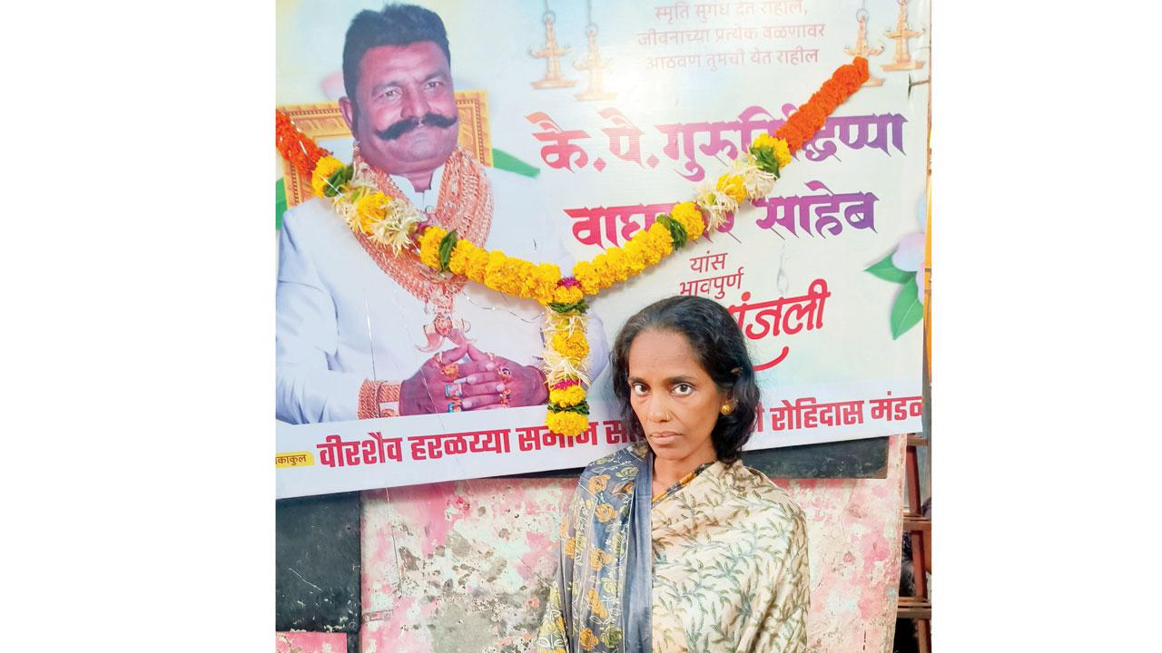The deceased’s wife Manisha in front of a poster of her husband