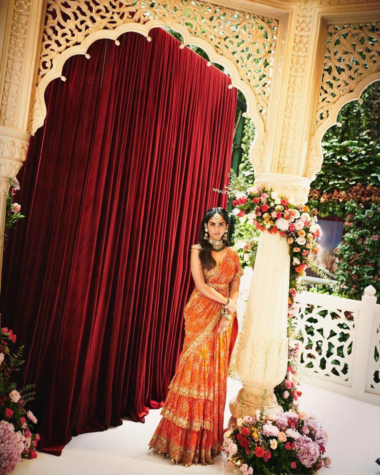 Isha Ambani Piramal wore a custom Arpita Mehta outfit in a deep orange tone. 