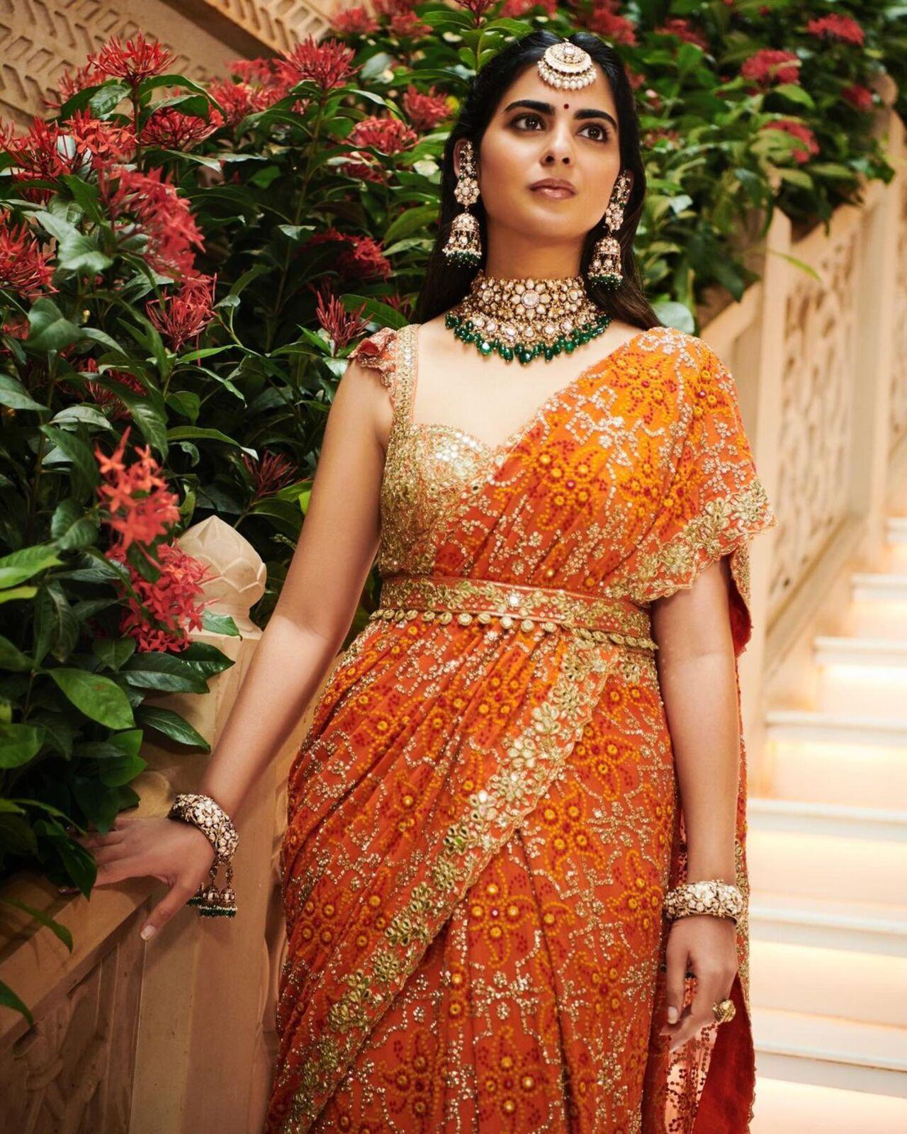 Isha accessorised her look with a heavy choker necklace, jhumkas, and a maang-teeka. 