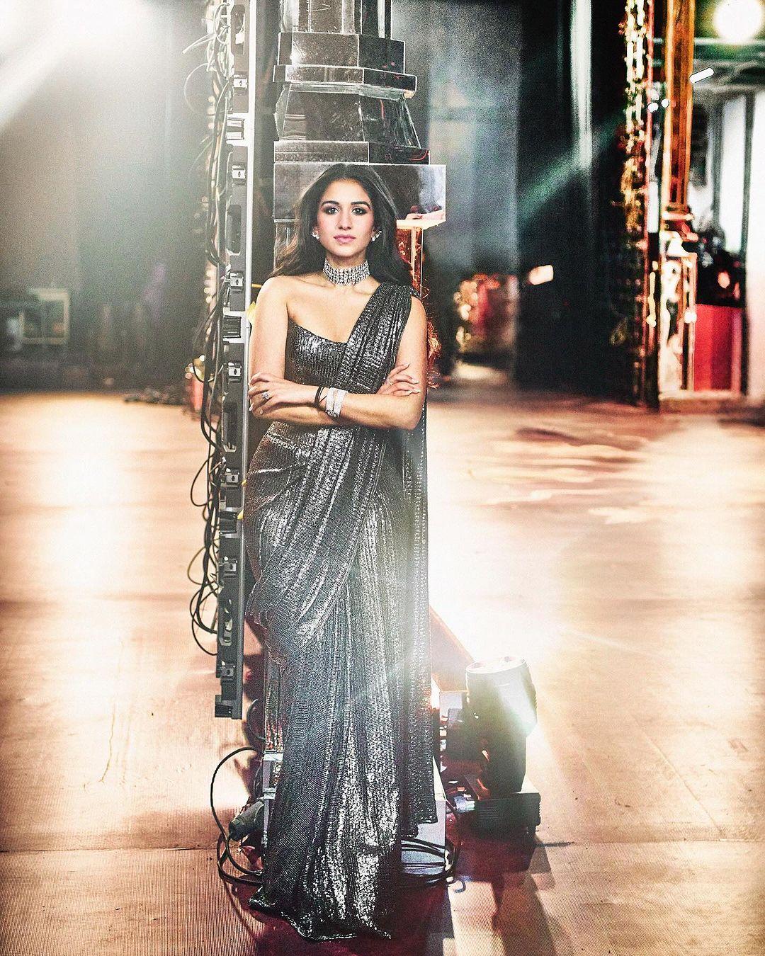 Radhika's second look featured a striking saree designed by Bollywood's beloved designer, Manish Malhotra. The saree was a captivating shade of black, embellished with a glamorous chainmail pattern.