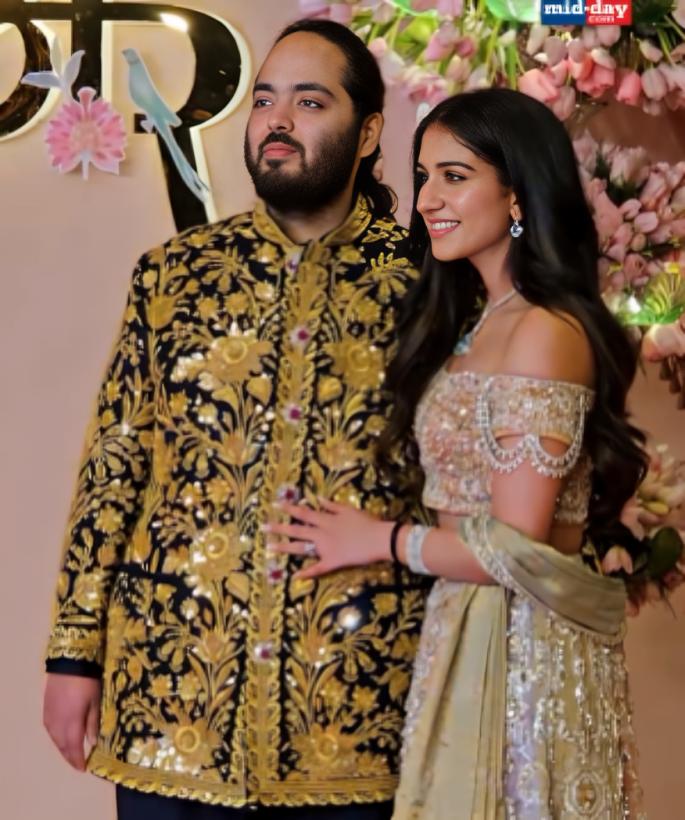 Radhika Merchant looked breathtaking in a silver sparkly off-shoulder lehenga adorned with beautiful silver zari work. The groom-to-be was seen in a golden-black sherwani suit. For their special night, the couple chose Abu Jani Sandeep Khosla