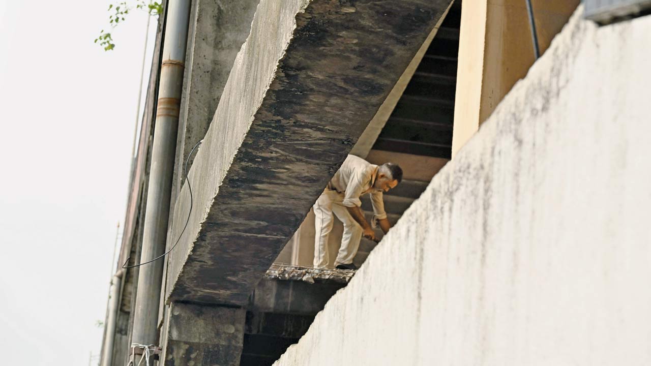 A worker was seen cleaning the spot on the flyover where the slab fell in Andheri. Pic/Anurag Ahire 