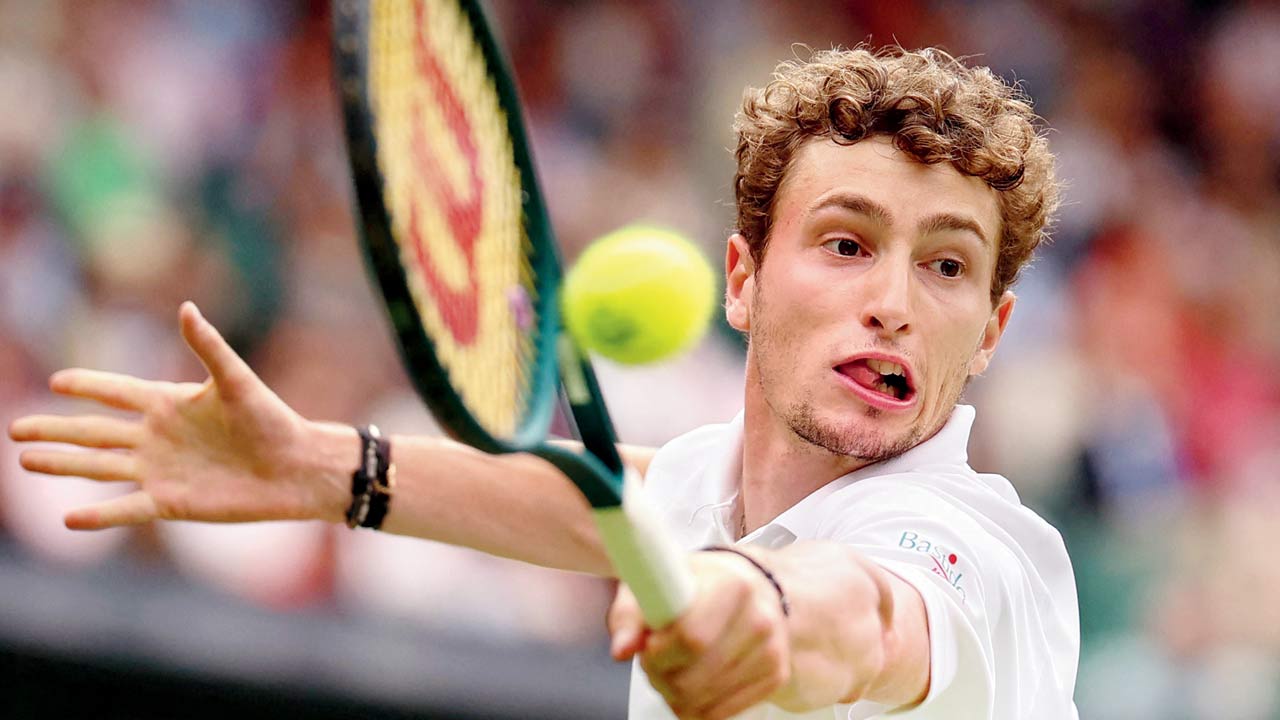 Ugo Humbert tackles Carlos Alcaraz at Wimbledon yesterday 