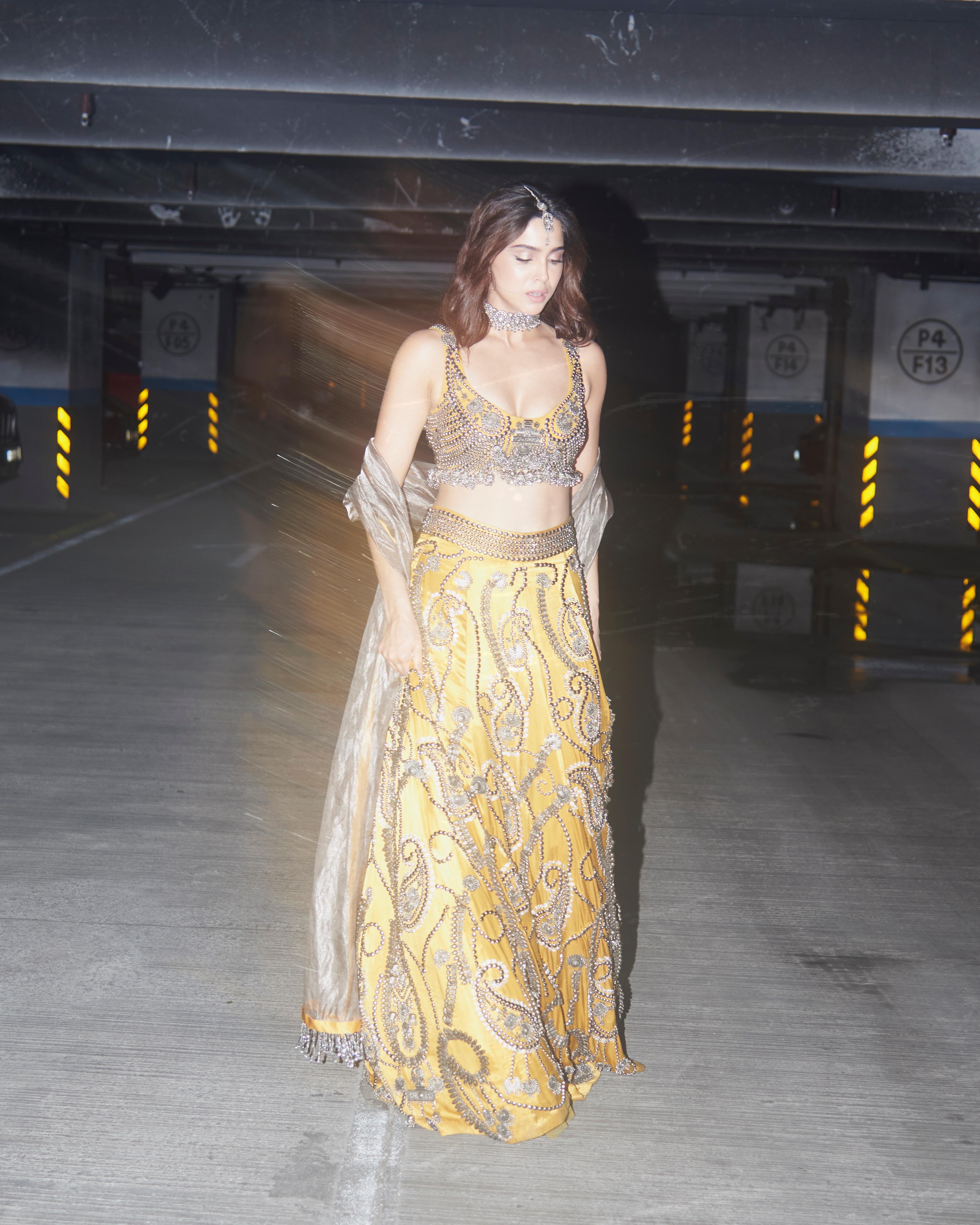 She effortlessly carries this heavy lehenga that has oxidised jewellery hand-stitched against a warm base of mustard yellow. 